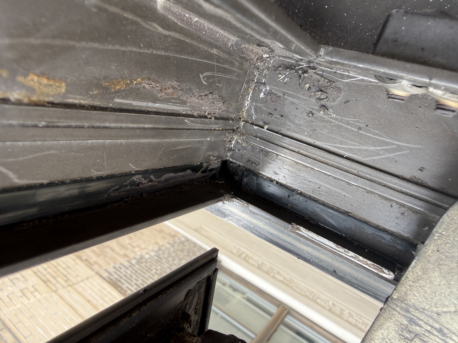 Hand-smeared sealant · scratches · open corner joint